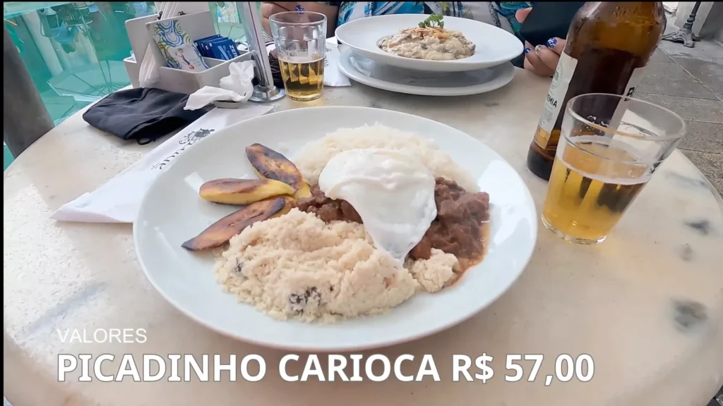 Prato de picadinho carioca com farofa, banana frita e ovo pochê