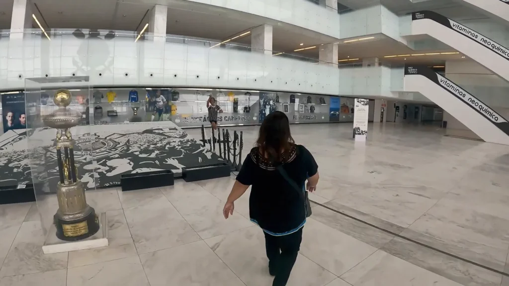 CORINTHIANS Neo Química Arena: Tour Completo pelo "Hospício" e Os Segredos da Casa do Povo 2 Átrio principal do estádio com troféu do Campeonato Paulista e estátua de Sócrates