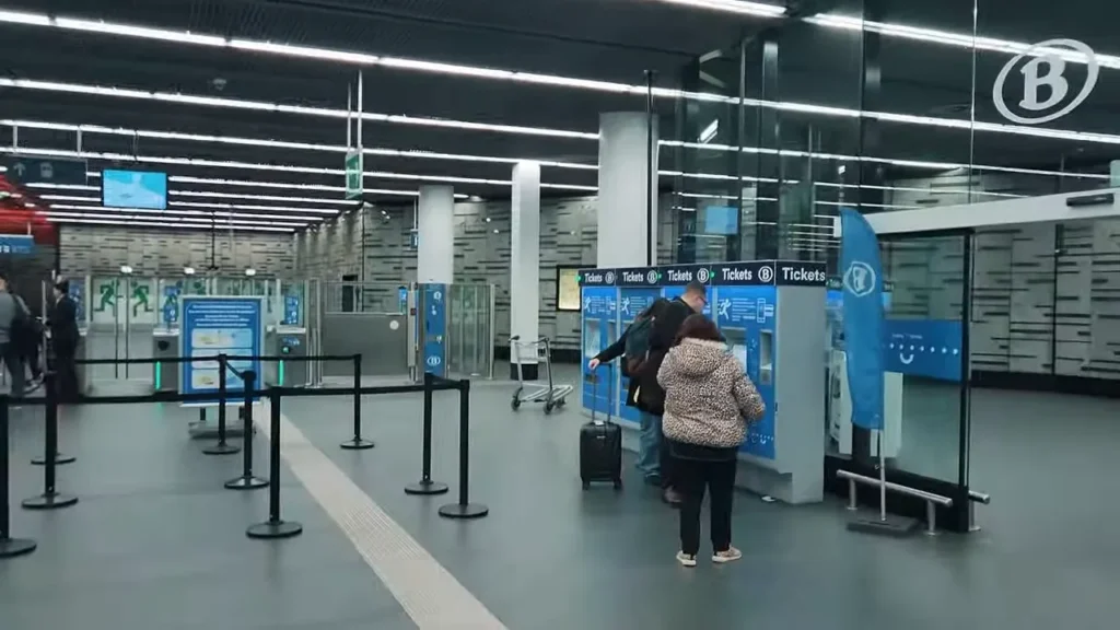 Máquinas automáticas de bilhetes e passageiros na estação do aeroporto