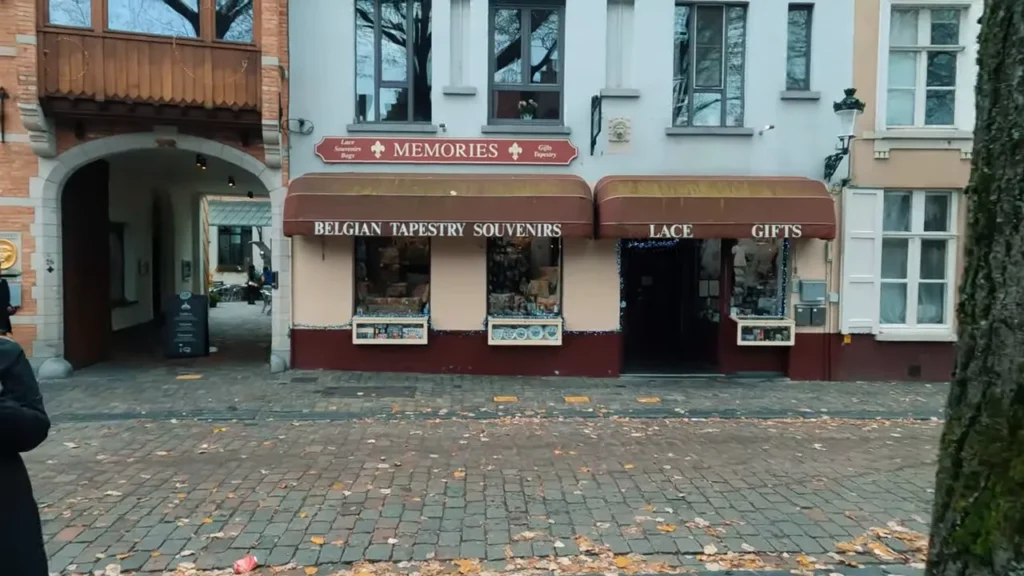 Fachada da loja 'Memories' em Bruges com toldos e vitrines de souvenirs