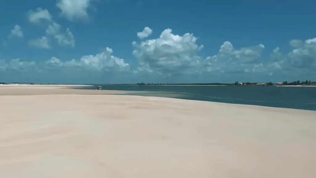 Bancos de areia e um canal entre ilhas na Praia do Saco sob céu azul com nuvens