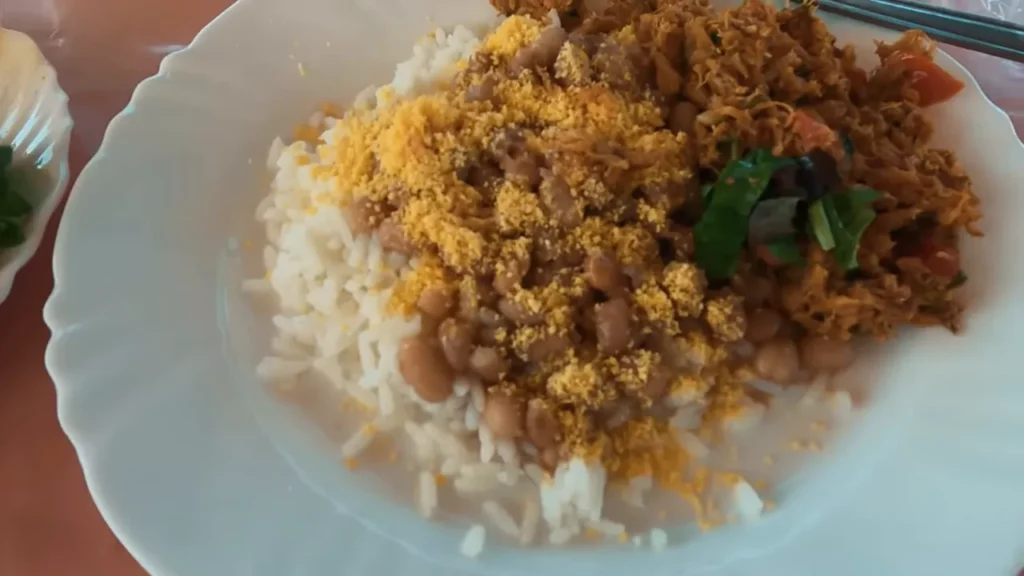 prato feito com arroz, feijão, farofa e peixe desfiado em restaurante