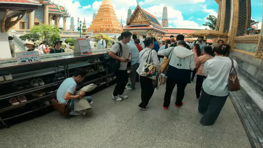 Pessoa retirando sapatos de uma prateleira no Grand Palace, mostrando o procedimento de deixar calçados.