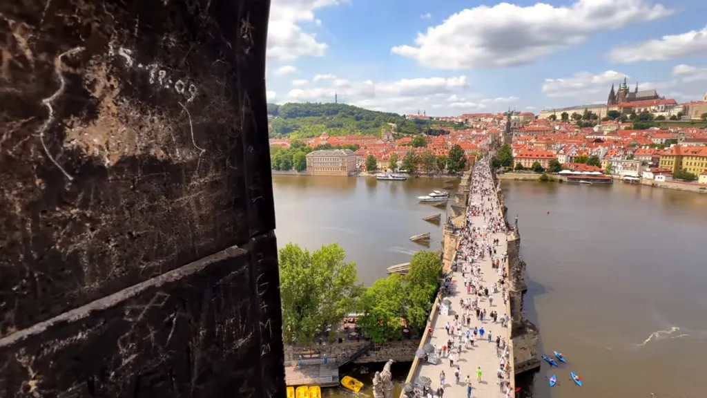 Ponte Carlos (Charles Bridge) e o rio Vltava com pedestres vista de cima da torre em Praga